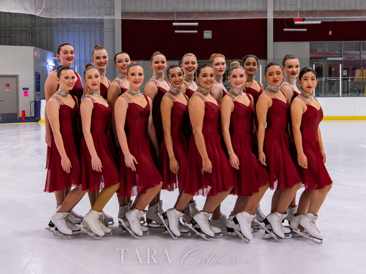 Synchronized skating team in custom burgundy costumes designed by TARA Costumes